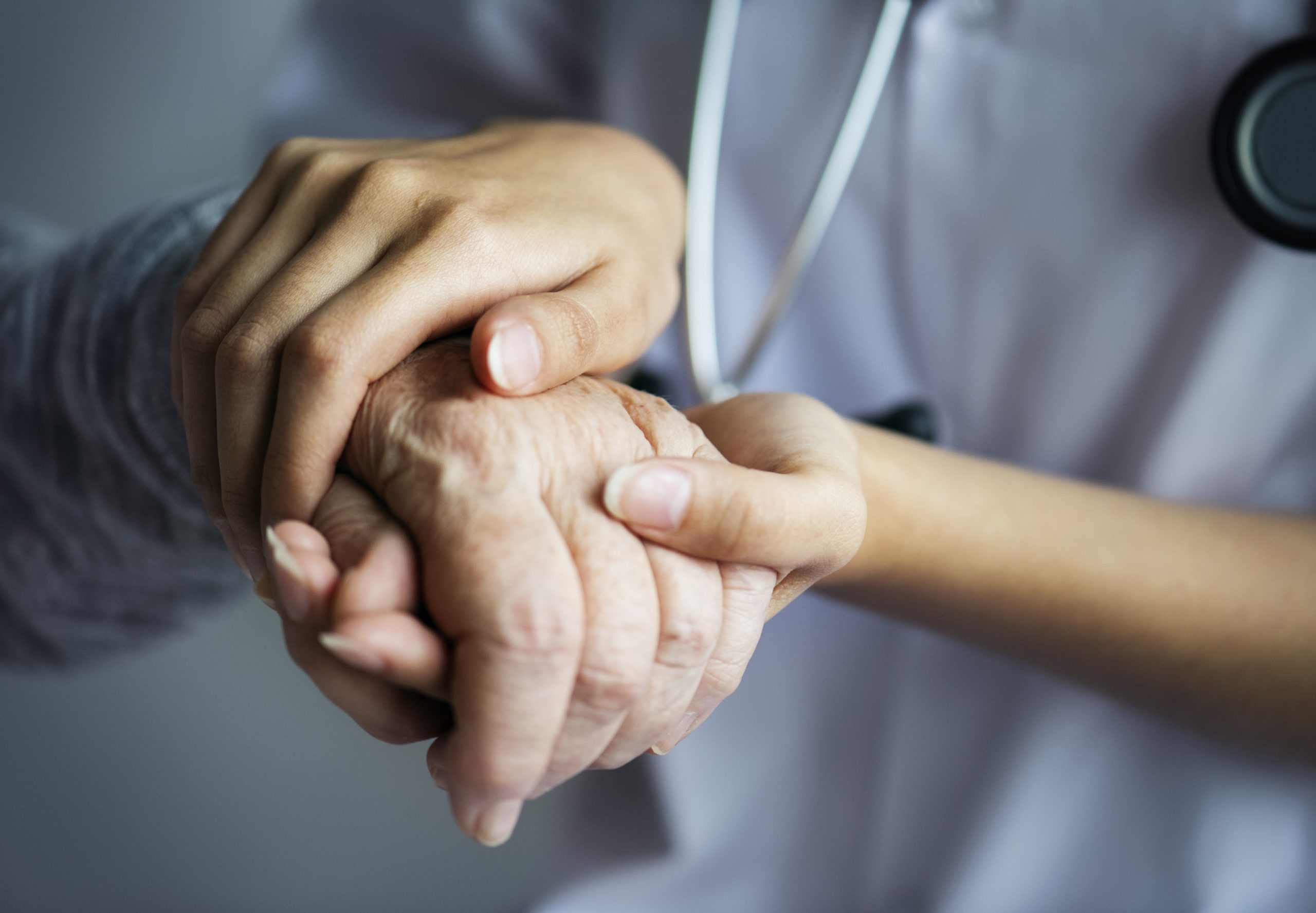 closeup of hands supporting an elderly