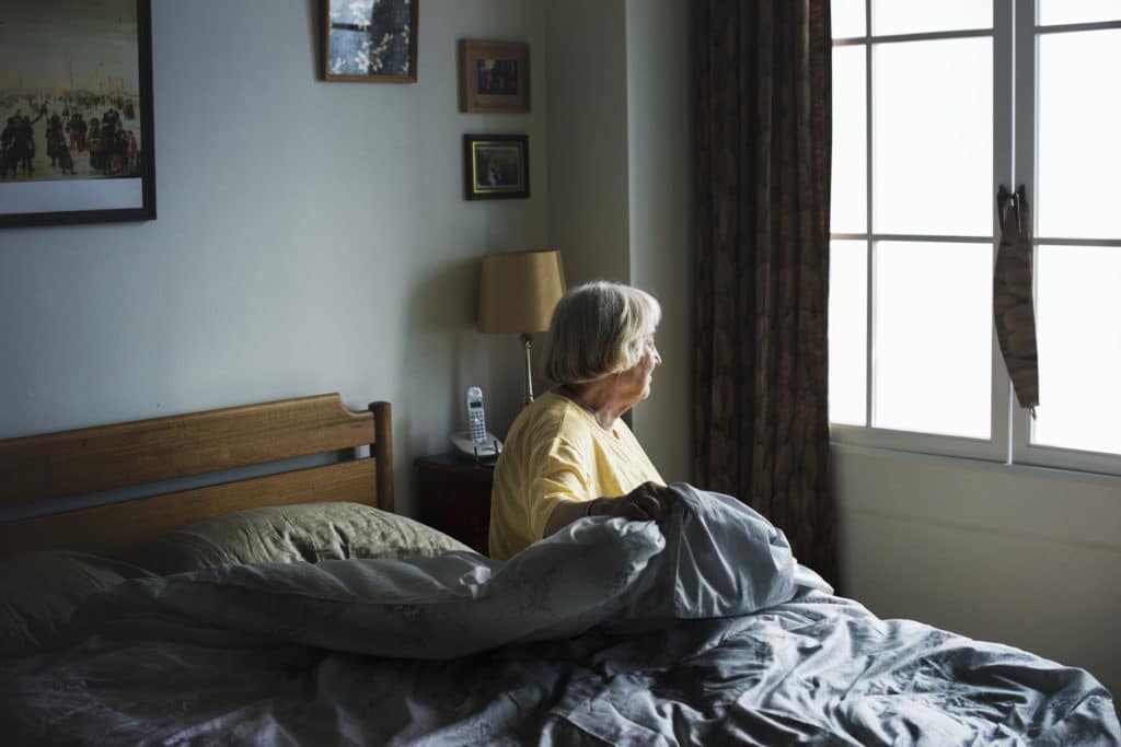 senior woman sitting in a bedroom