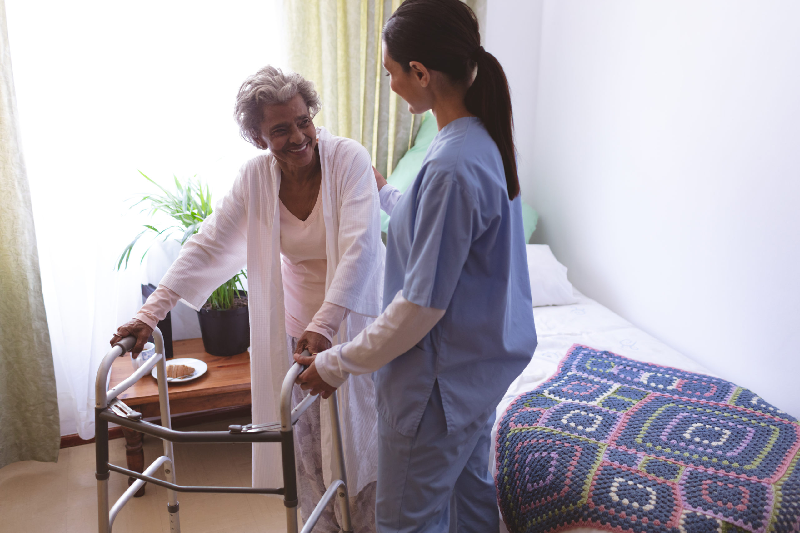 female nurse helping senior female patient