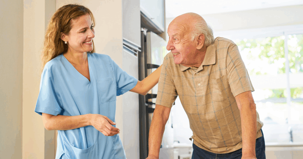 Caregiver smiling at senior man using a walker.