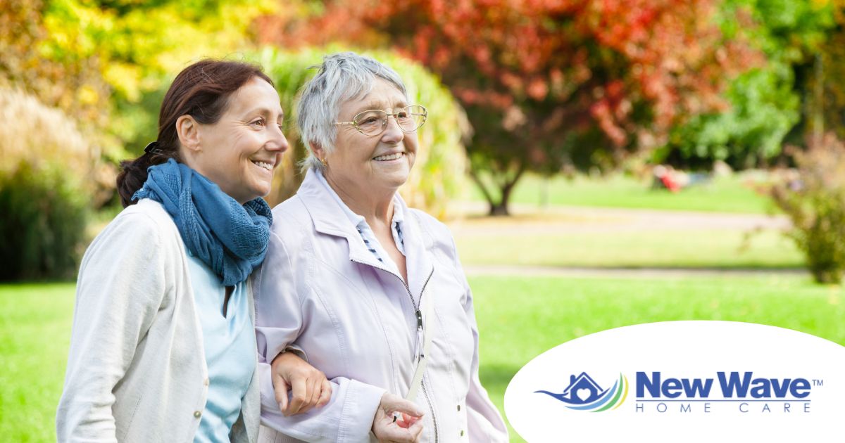 A recently retired woman enjoys her caregiving job as she walks with a senior client outside.