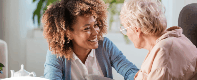 A woman enjoys compassionately providing caregiving services to an elderly woman.