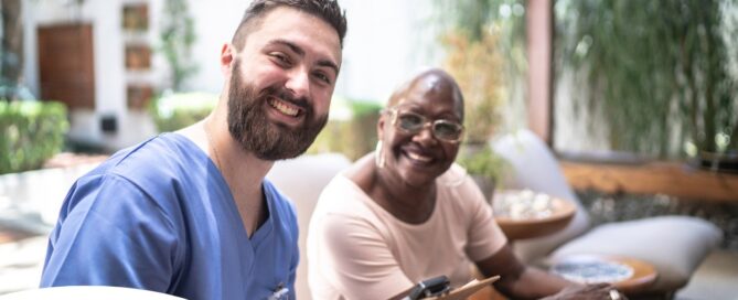 A man enjoys his caregiver job as he works with a client.
