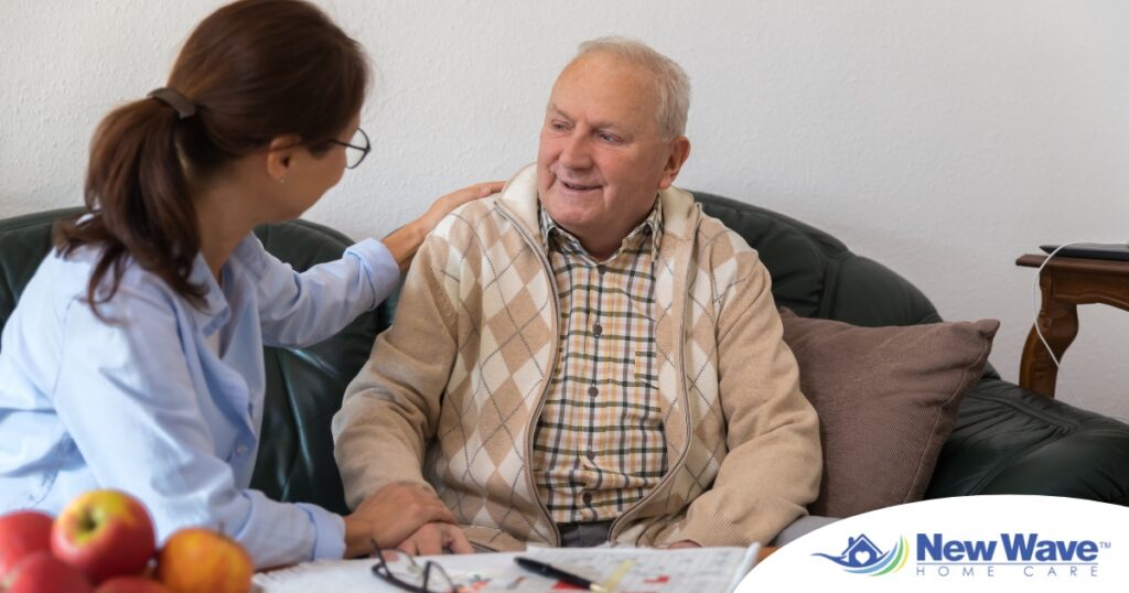 A caregiver compassionately listens to an older man, representing the kind of patience and empathy that help with communicating with clients who have dementia.