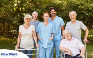 2 caregivers and seniors smile while in a group representing how caregivers can facilitate socialization.