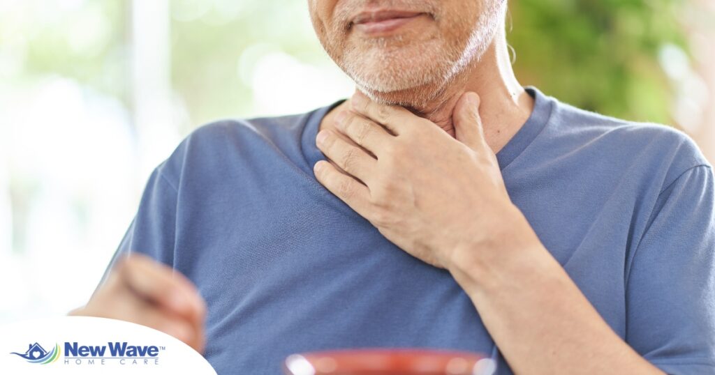 An older adult holds his throat representing dysphagia which can affect senior health.