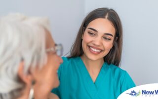 A caregiver smiles with an older client showing the results of successfully starting a new caregiving job.