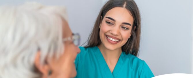 A caregiver smiles with an older client showing the results of successfully starting a new caregiving job.