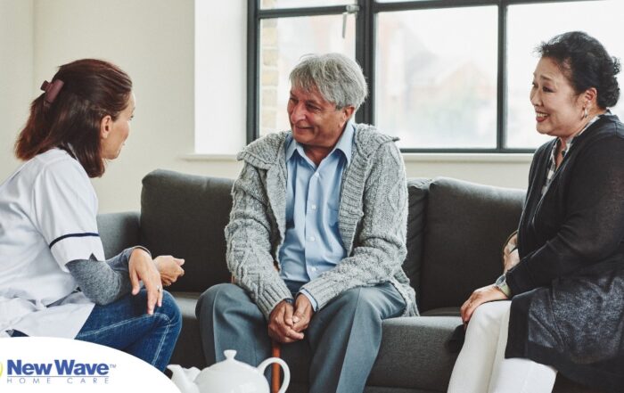 A caregiver talks with an elderly couple representing the kind of communication that professional caregivers need to have to anticipate client needs.
