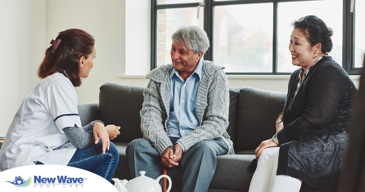 A caregiver talks with an elderly couple representing the kind of communication that professional caregivers need to have to anticipate client needs.