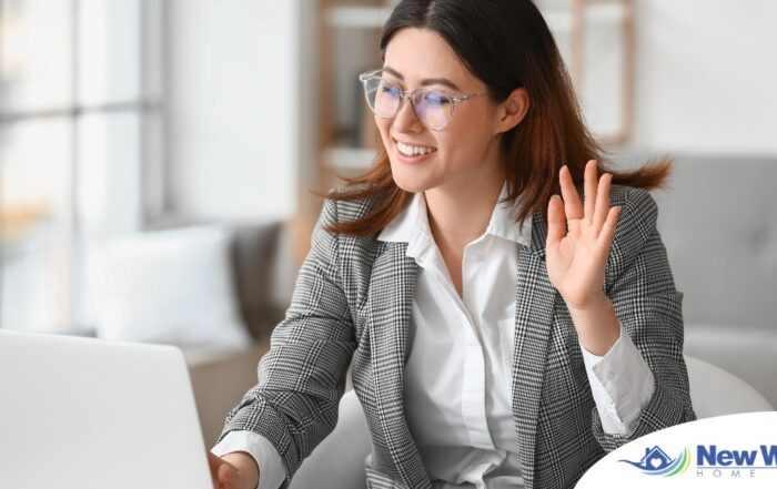 A well-dressed woman smiles and says hi on a videoconference, representing a candidate who is well-prepared for a caregiver interview.