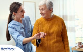 A caregiver helps a client get around, demonstrating one of the job duties of a caregiver.