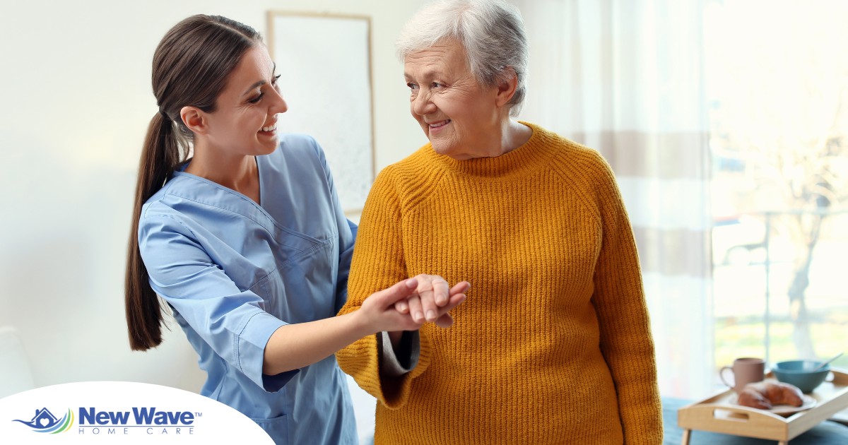A caregiver helps a client get around, demonstrating one of the job duties of a caregiver.