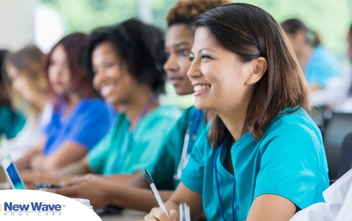 Several students in scrubs happily attend a class, representing caregiver training.
