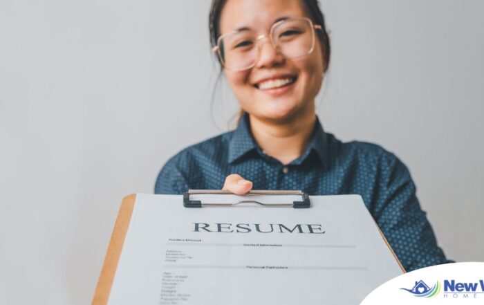 A woman happily hands in a resume, representing a successfully written caregiver resume.