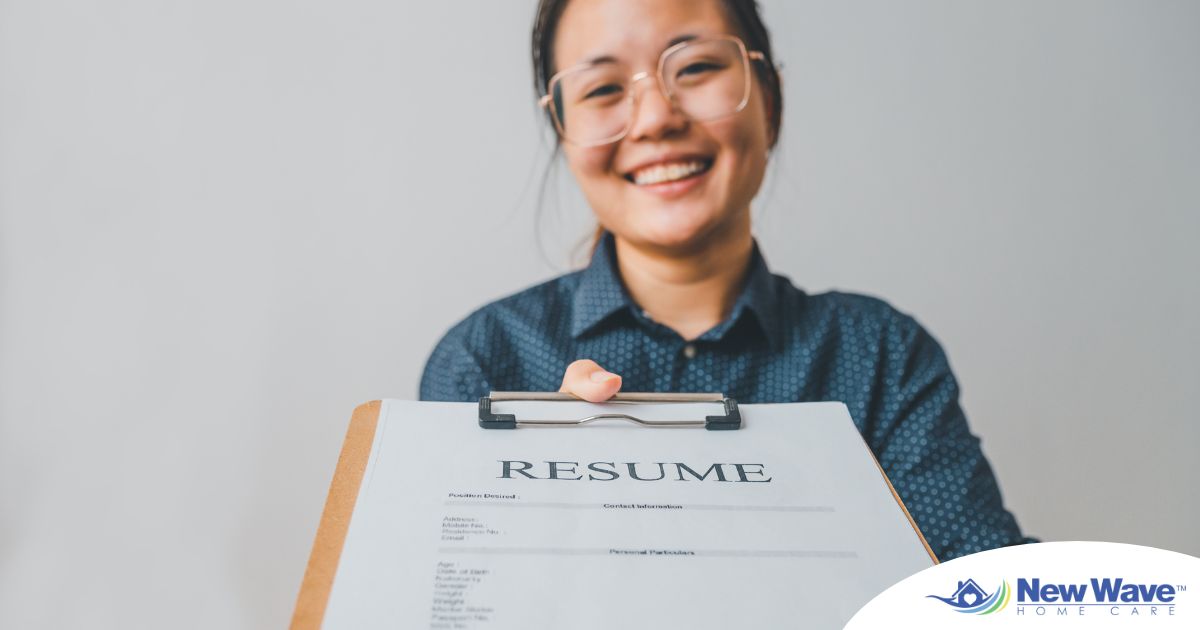 A woman happily hands in a resume, representing a successfully written caregiver resume.