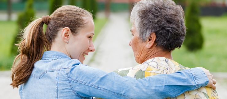 A caregiver walks beside an elderly woman outdoors, offering companionship and emotional support as part of respite home care services in Glendale, California.