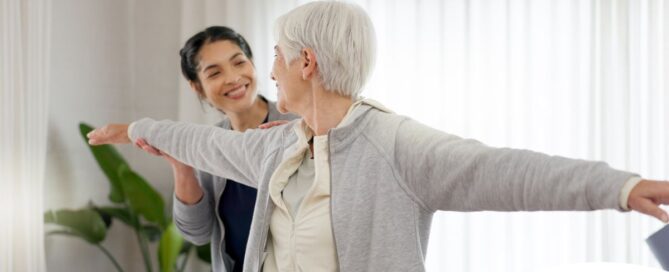 A caregiver and senior practice tai chi as one of many enriching activities for seniors at home.