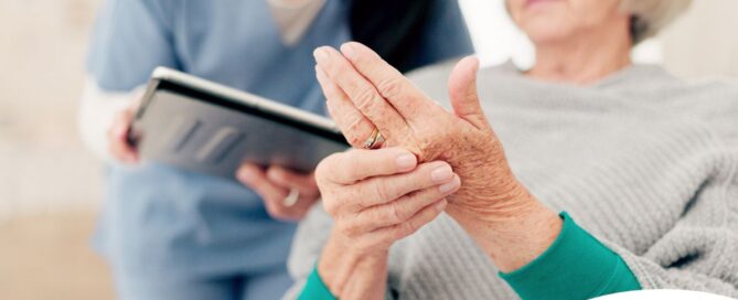 A caregiver provides in home care services to a senior with arthritis