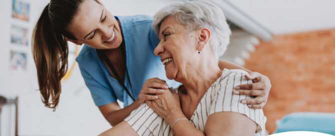 A female caregiver helping an older woman with stroke recovery at home.